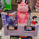 A pink gorilla plush sits on top of a display of retro games.